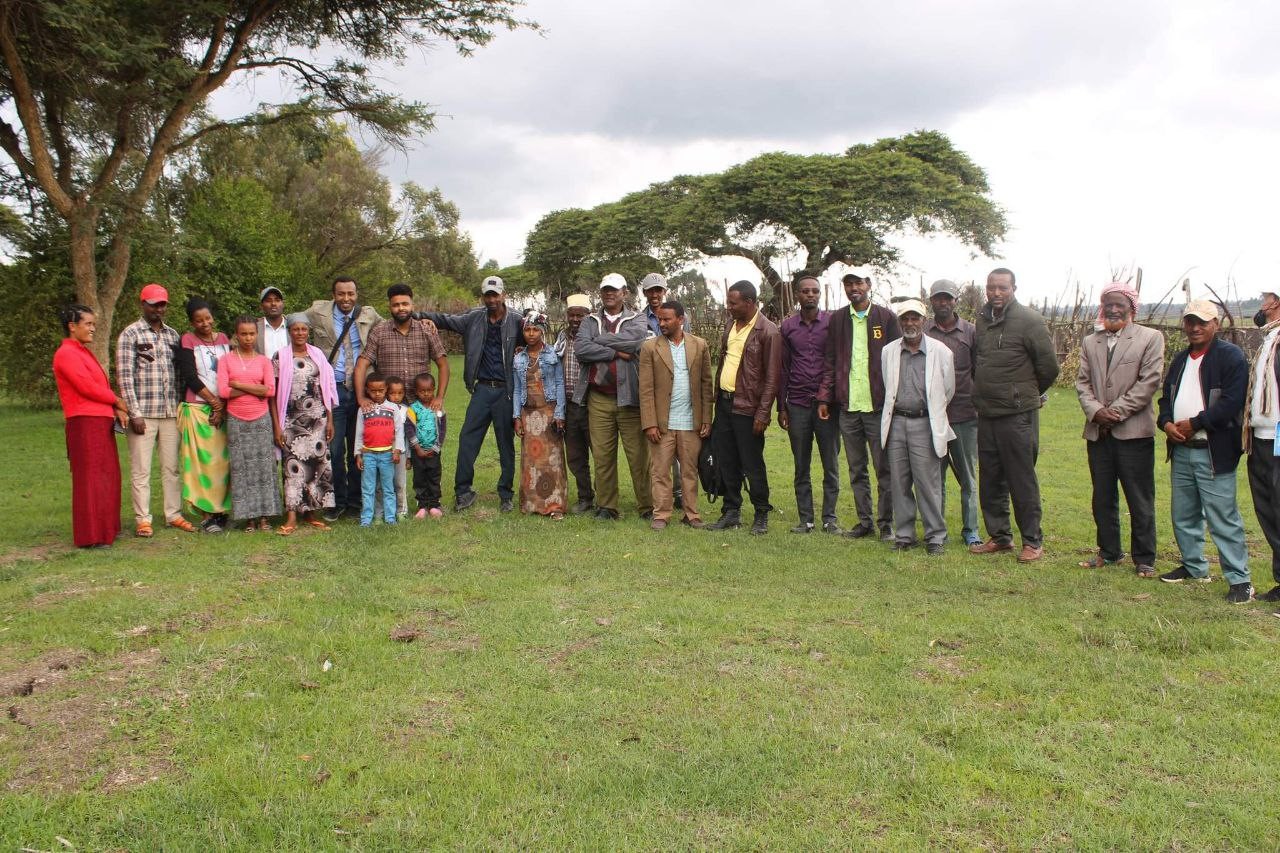 A group of people stand together outside during a meeting with Fidel Birhan.